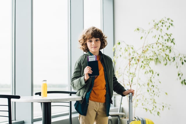 Boy Holding Passport With Suitcase