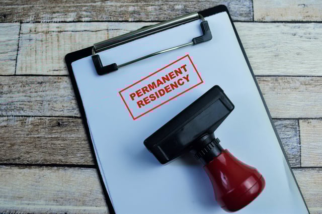 แนวคิดเรื่องการขอถิ่นพำนักถาวร เขียนลงบนเอกสาร แยกออกมาจากพื้นหลังไม้