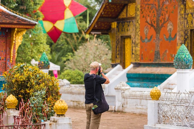 ชายคนหนึ่งกำลังถ่ายภาพวัดในหลวงพระบาง ประเทศลาว