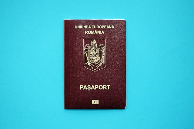 Romanian Passport Book On Light Blue Paper Background