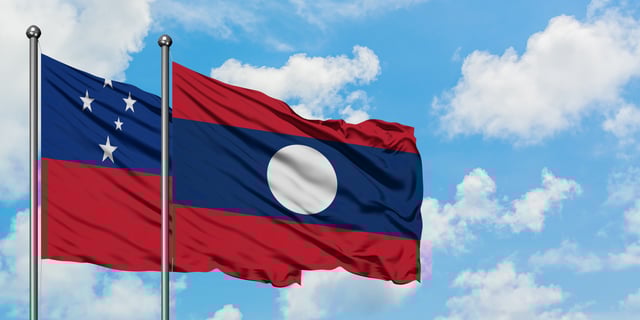 Samoa And Laos Flag Waving In The Wind Against White Cloudy
