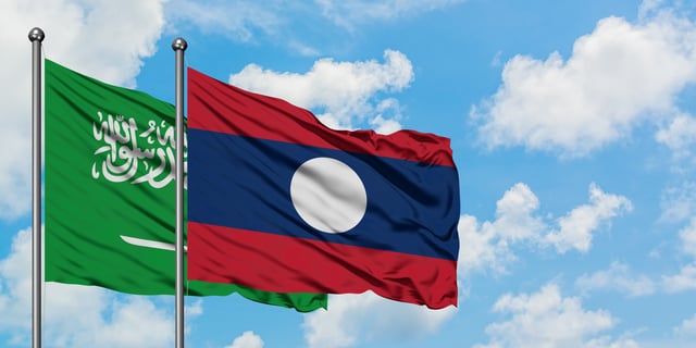 Saudi Arabia And Laos Flag Waving In The Wind Against White Cloudy
