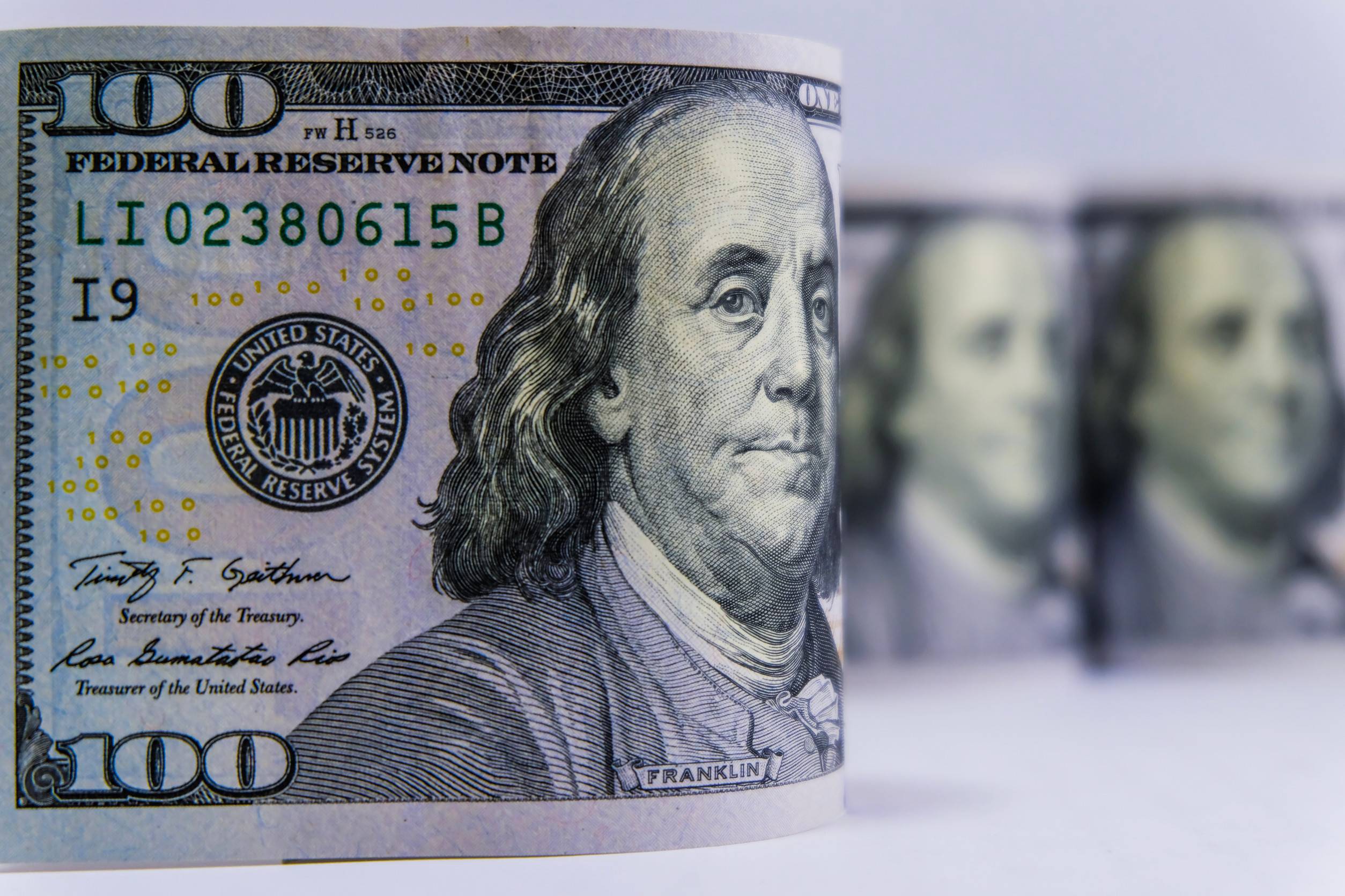 Close-up of US dollar rolls on a white background, representing the financial aspect of travel